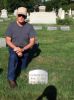 Eben Wilson 'Buzz' Noyes kneeling beside the gravestone of his 2-great grandfather Ebenezer Noyes
